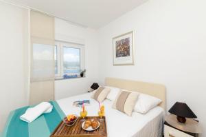 ein Schlafzimmer mit einem Bett und einem Tablett mit Essen drauf in der Unterkunft Apartments Maja in Okrug Donji