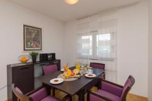 a dining room with a table and purple chairs at Apartments Maja in Okrug Donji