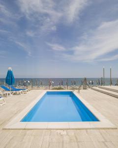a swimming pool with the ocean in the background at Hotel Marcelli in Numana