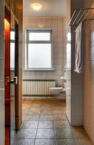 een badkamer met een toilet en een raam bij Guest House on Sadovaya in Alma-Ata