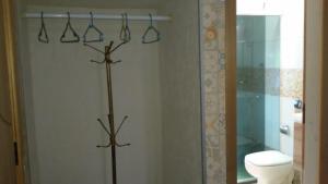 a bathroom with a toilet and some hangers in it at Pousada Chalé Morada in Valparaíso de Goiás +28 photos