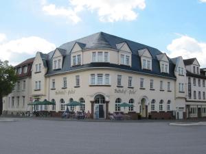 Bahnhof-Hotel Saarlouis في سارلويس: مبنى ابيض كبير بسقف اسود