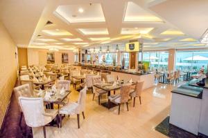 un ristorante con tavoli e sedie e un bar di Savero Hotel Depok a Depok