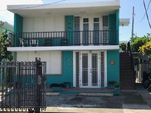 a green and white house with a balcony at Luquillo Beach Vacation in Luquillo