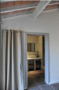 a bathroom with a shower curtain and a sink at L'Olivette in Montagnac