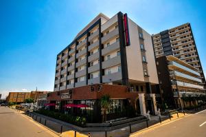 a large building on the side of a street at Grand Park Hotel The Luxueux Minami Kashiwa in Kashiwa