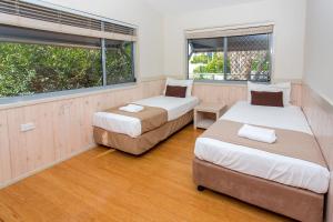 two beds in a room with two windows at BIG4 Park Beach Holiday Park in Coffs Harbour +165 photos