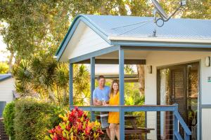 Un uomo e una donna in piedi sul portico di una casa di BIG4 Park Beach Holiday Park a Coffs Harbour