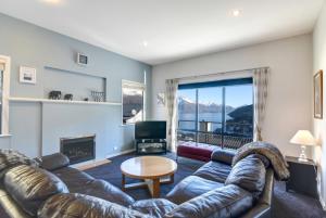 a living room with a leather couch and a table at The Queenstown Bothy in Queenstown