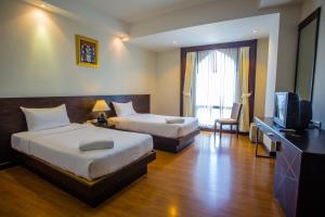 Habitación de hotel con 2 camas y TV en Grande Southern Hotel, en Thung Song