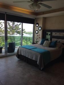 a bedroom with a large bed and a large window at Cozy and Modern in Cancún