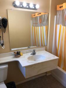 a bathroom with a sink and a large mirror at Encore Motel in Los Angeles