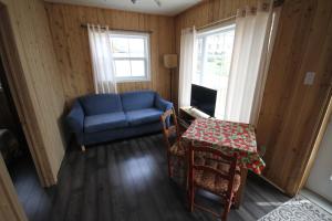 uma sala de estar com uma mesa e um sofá azul em Tadou-Shack em Tadoussac