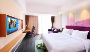 een hotelkamer met een bed en een televisie bij Hampton by Hilton Zhuhai Cheng Feng Plaza in Zhuhai