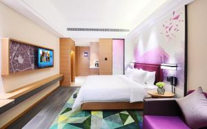 um quarto de hotel com uma cama e um sofá em Hampton by Hilton Zhuhai Cheng Feng Plaza em Zhuhai