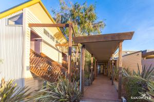 a house with a wooden walkway on the side of it at Sandpiper Motel Apollo Bay in Apollo Bay