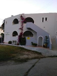 Biały budynek ze spiralnymi schodami przed nim w obiekcie Afroditi Studios w mieście Sivota