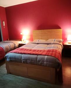- une chambre avec 2 lits aux murs rouges dans l'établissement Habitaciones en Buena Vista, à Lima