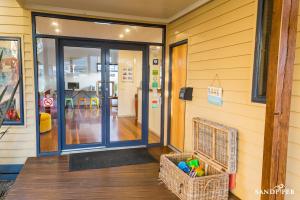 a front door of a store with a basket on the porch at Sandpiper Motel Apollo Bay in Apollo Bay