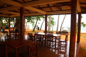 Under Water Safaris and Resort في ترينكومالي: مطعم بطاولات وكراسي وملعب