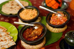 uma mesa coberta com tigelas de comida em pratos em Meena Amma's Tea Experience em Ambawela