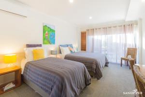 a hotel room with two beds and a window at Sandpiper Motel Apollo Bay in Apollo Bay