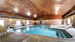 a swimming pool in a building with a wooden ceiling at Motel 6-Altoona, IA - Des Moines East in Altoona