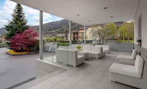 a patio with white furniture and a view of a mountain at Best Western Hotel Nuovo in Garlate