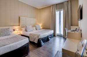 a hotel room with two beds and a television at Hotel Nuovo in Garlate