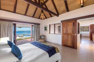 a bedroom with a bed and a view of the ocean at Eratap Beach Resort in Port Vila