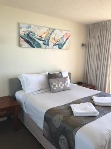 a hotel room with two beds with towels on them at Gemini Resort in Caloundra