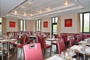 a dining room with tables and red chairs at Best Western Plus Hotel des Francs in Soissons
