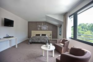a bedroom with a bed and a table and chairs at Best Western Plus Villa Saint Antoine Hotel & Spa in Clisson