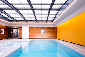 uma piscina interior com tecto e piscina em Best Western Premier Hotel de la Paix em Reims