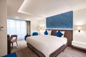 a hotel room with a large bed and a desk at Keizershof Hotel Aalst in Aalst +135 photos
