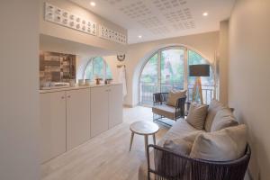 a living room with a couch and a kitchen at Best Western Plus Villa Saint Antoine Hotel & Spa in Clisson