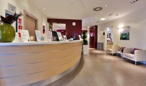 a lobby with a bar in a hospital with chairs at Best Western Palace Inn Hotel in Ferrara