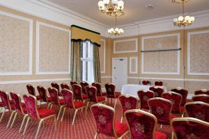 a conference room with red chairs and a table in it at Belvilla Crewe Arms Hotel in Crewe