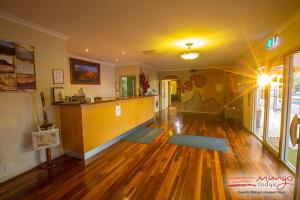 a living room with a hard wood floor and a kitchen at Mungo Lodge in Mungo