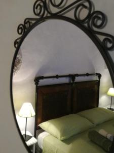 - un miroir réfléchissant le lit dans la chambre dans l'établissement Il Gallo Del Vicino, à Monte Urano