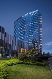 a tall building with a sign on top of it at Hyatt Regency Xiamen Wuyuanwan in Xiamen