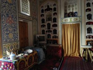 um quarto com uma mesa e uma cortina num quarto em Hotel Mosque Baland em Bukhara