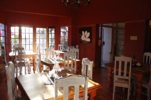 a dining room with a wooden table and chairs at Cecil John Rhodes Guest House in Kimberley
