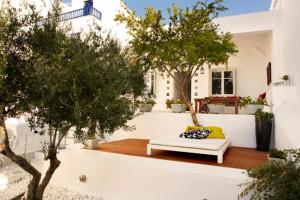 a patio with a white couch and some trees at Casa Aiora in Adamantas