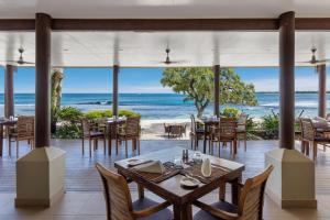 ein Restaurant am Strand mit Tischen und Stühlen in der Unterkunft Eratap Beach Resort in Port Vila