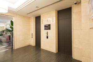 a hallway with a black door in a building at Sotetsu Grand Fresa Osaka-Namba in Osaka