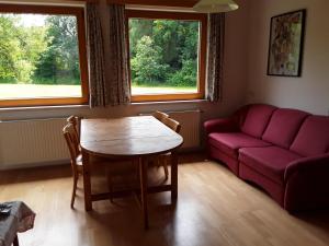 ein Wohnzimmer mit einem roten Sofa und einem Tisch in der Unterkunft Gästehaus Kuchernig in Völkermarkt
