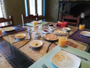 einen Tisch mit Teller mit Speisen und Orangensaft in der Unterkunft Villa du Souss in Agadir