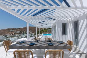 a dining room with a table and chairs at Sealine Villas in Tourlos