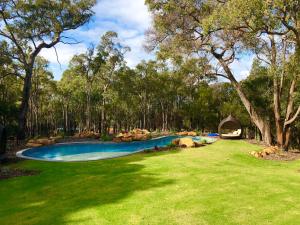 a swimming pool in the middle of a yard with trees at Amaroo Retreat & Spa in Mount Helena